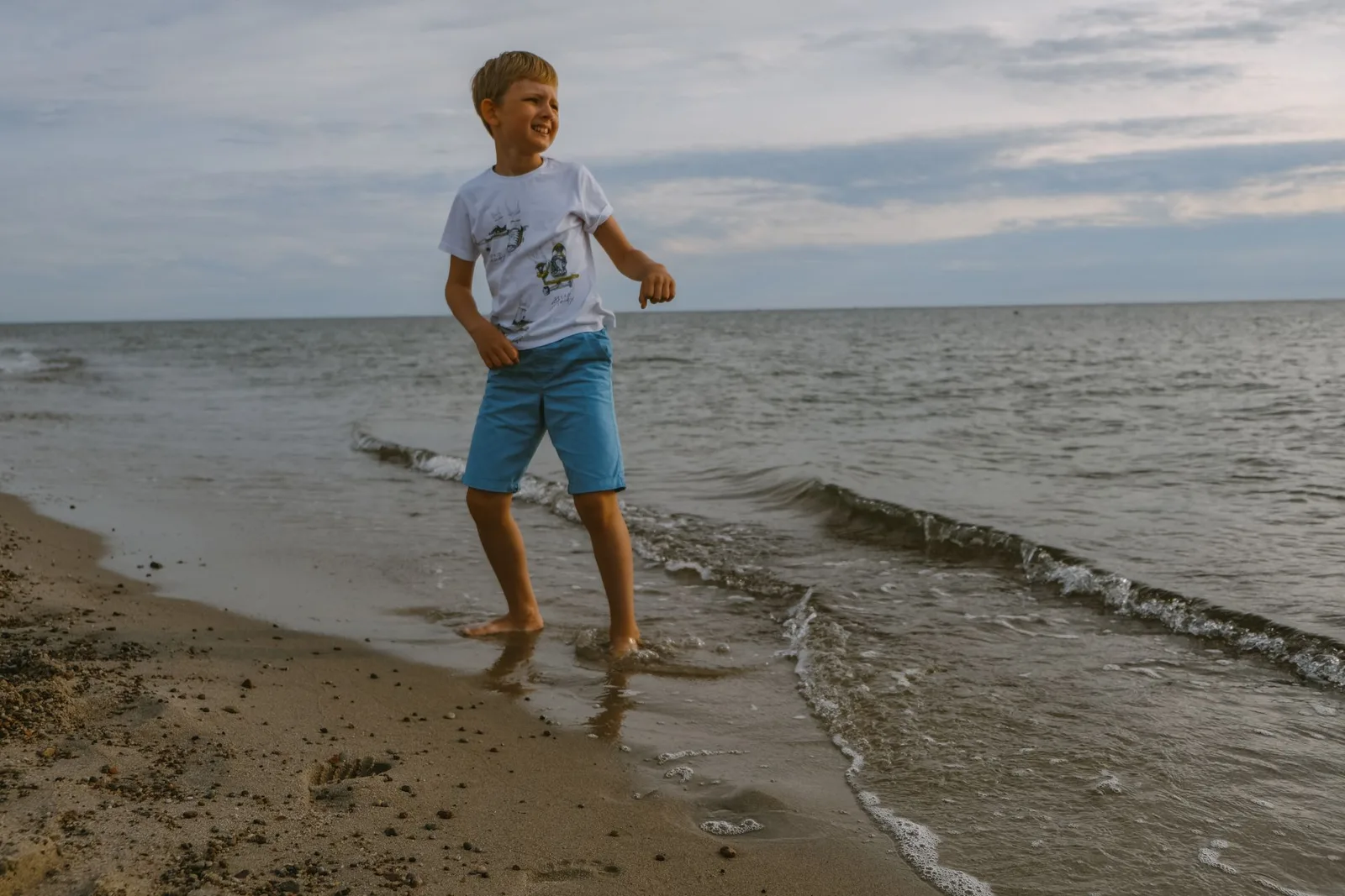 Мальчик по щиколотку в море: проверяет, можно ли уже звать родителей. Фото: Настя Шафранова